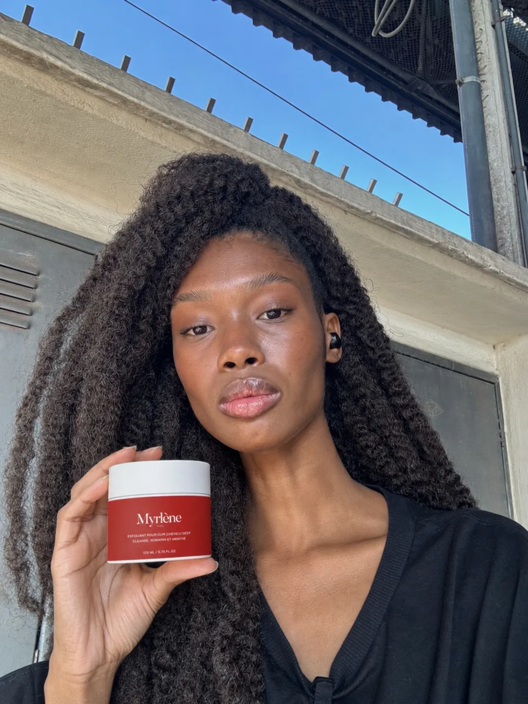 Exfoliant pour cuir chevelu Myrlène Paris tenu en main